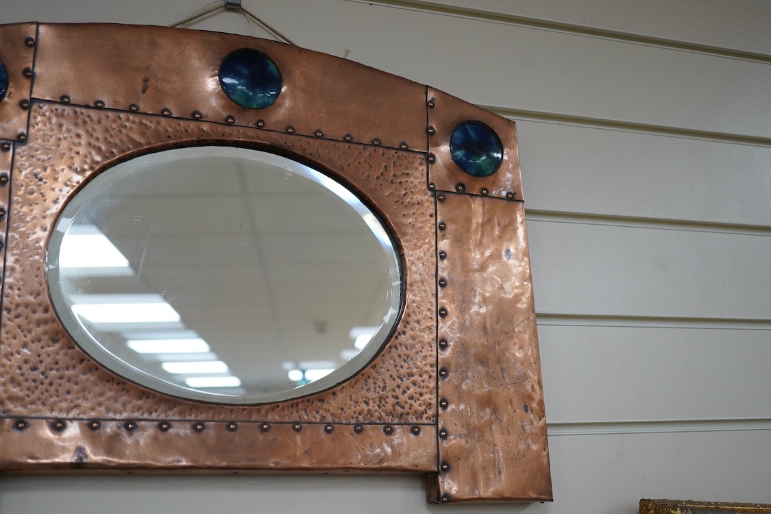 An Arts and Crafts riveted copper and Ruskin pottery cabochon inset mirror, 39cm high
